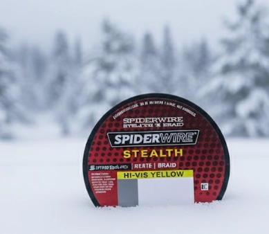 Winter fishing braid spool on snow for coldwater pike fishing