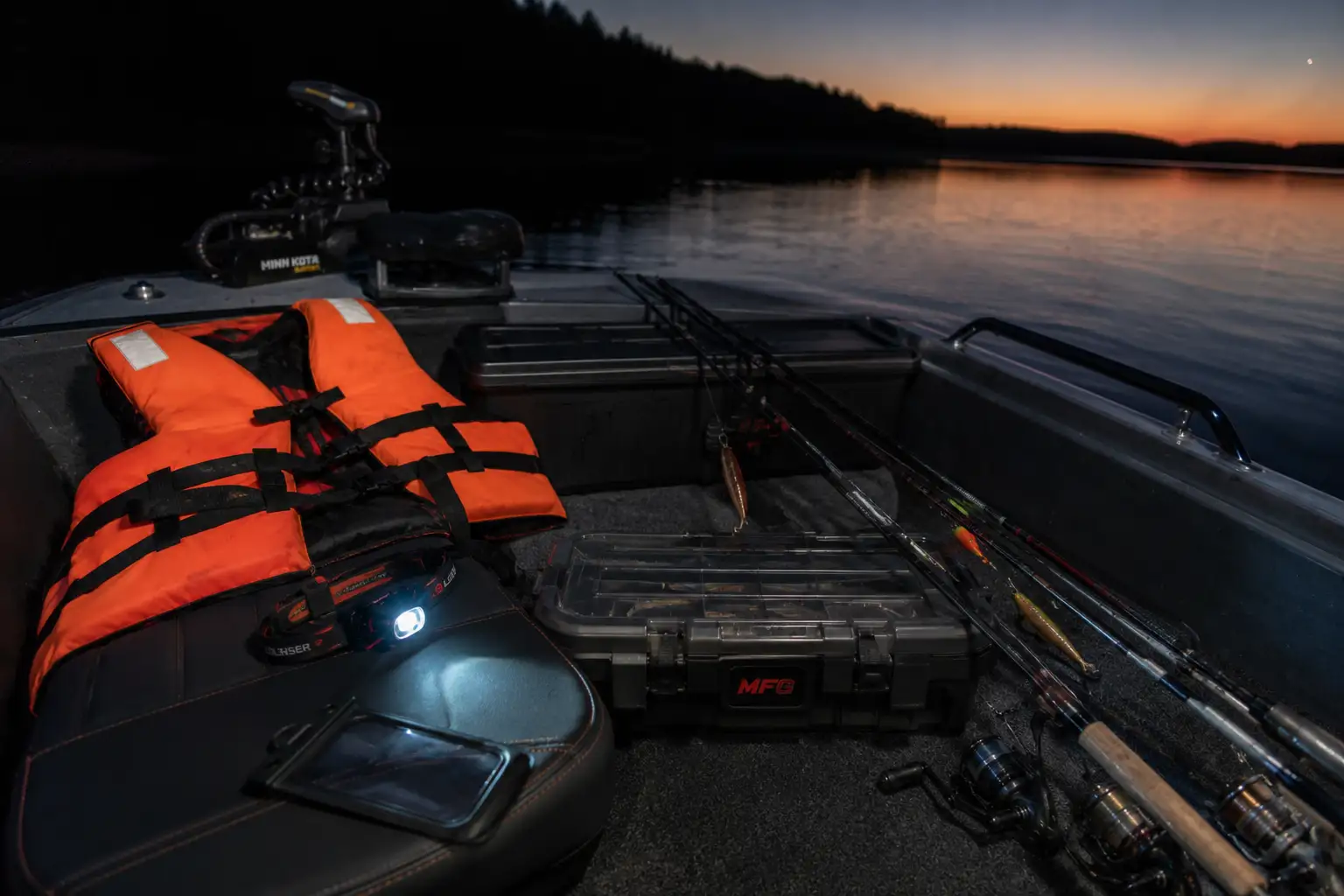 Night fishing gear laid out in a boat before a summer night pike fishing session — life jacket and headlamp ready
