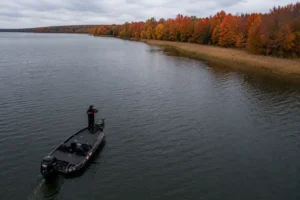 MFG angler demonstrating where to find pike in fall by casting toward a weed edge from deep offshore water