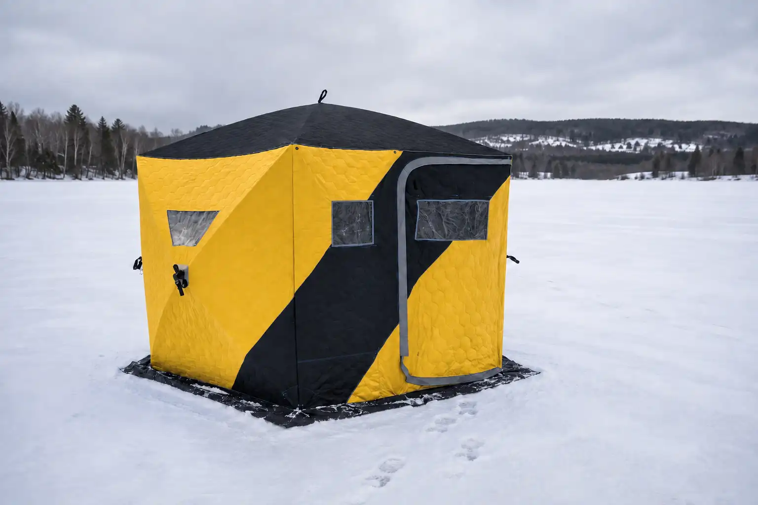 Hub-style ice fishing shelter set up on a frozen lake
