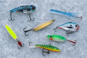 Our tested assortment of ice fishing lures for pike including spoons, swimbaits, and jigs on ice