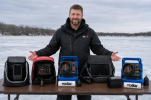 alt="MFG angler with five tested ice fishing fish finders including Vexilar, MarCum, and Garmin models"