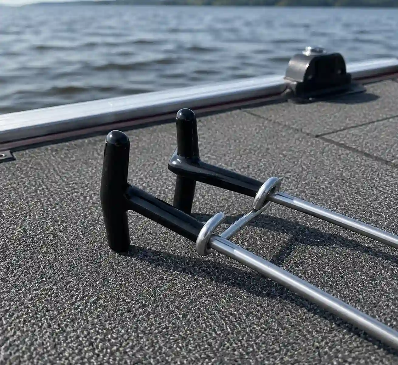 Close-up of the Zerone jaw spreader's rubberized handle on the boat deck, gentle on a pike's jaw during release