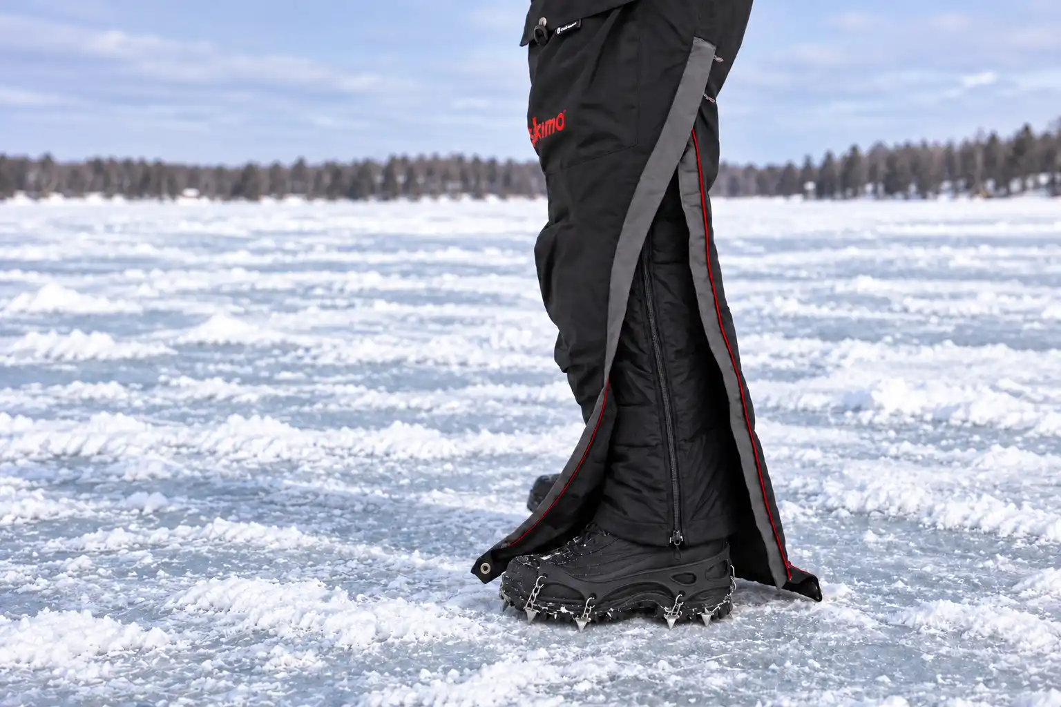 Eskimo Superior ice fishing bib with side zipper opened over an insulated boot and ice cleats