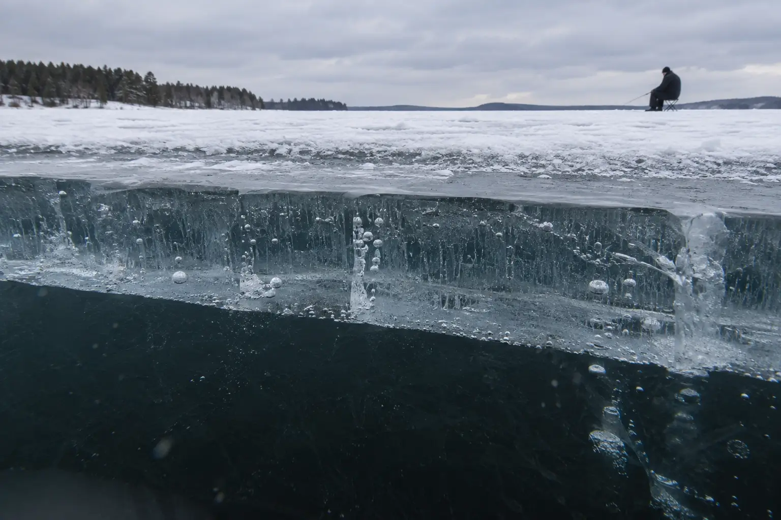 Ice fishing safety on thick clear ice with an MFG angler fishing in the distance